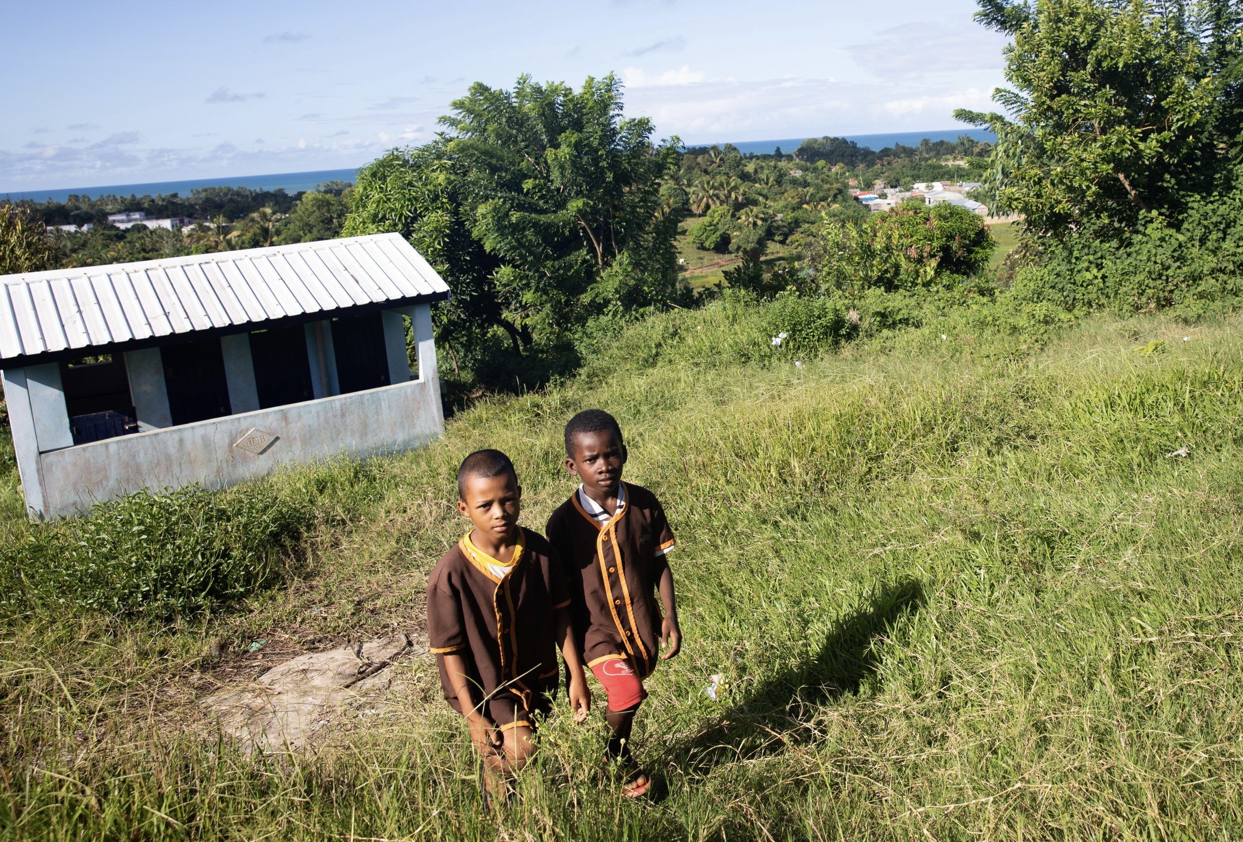 Två pojkar går upp för en grässlänt på Madagaskar.