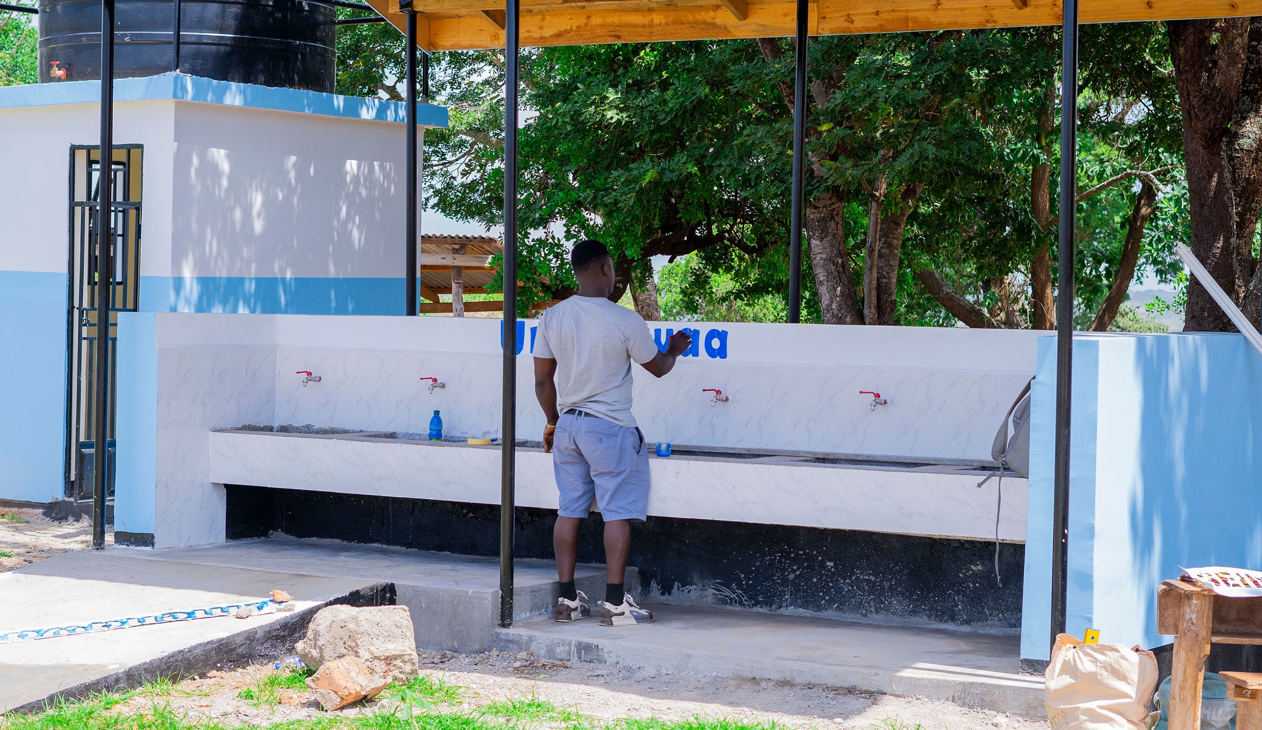 En man målar en text ovanför ett handfat