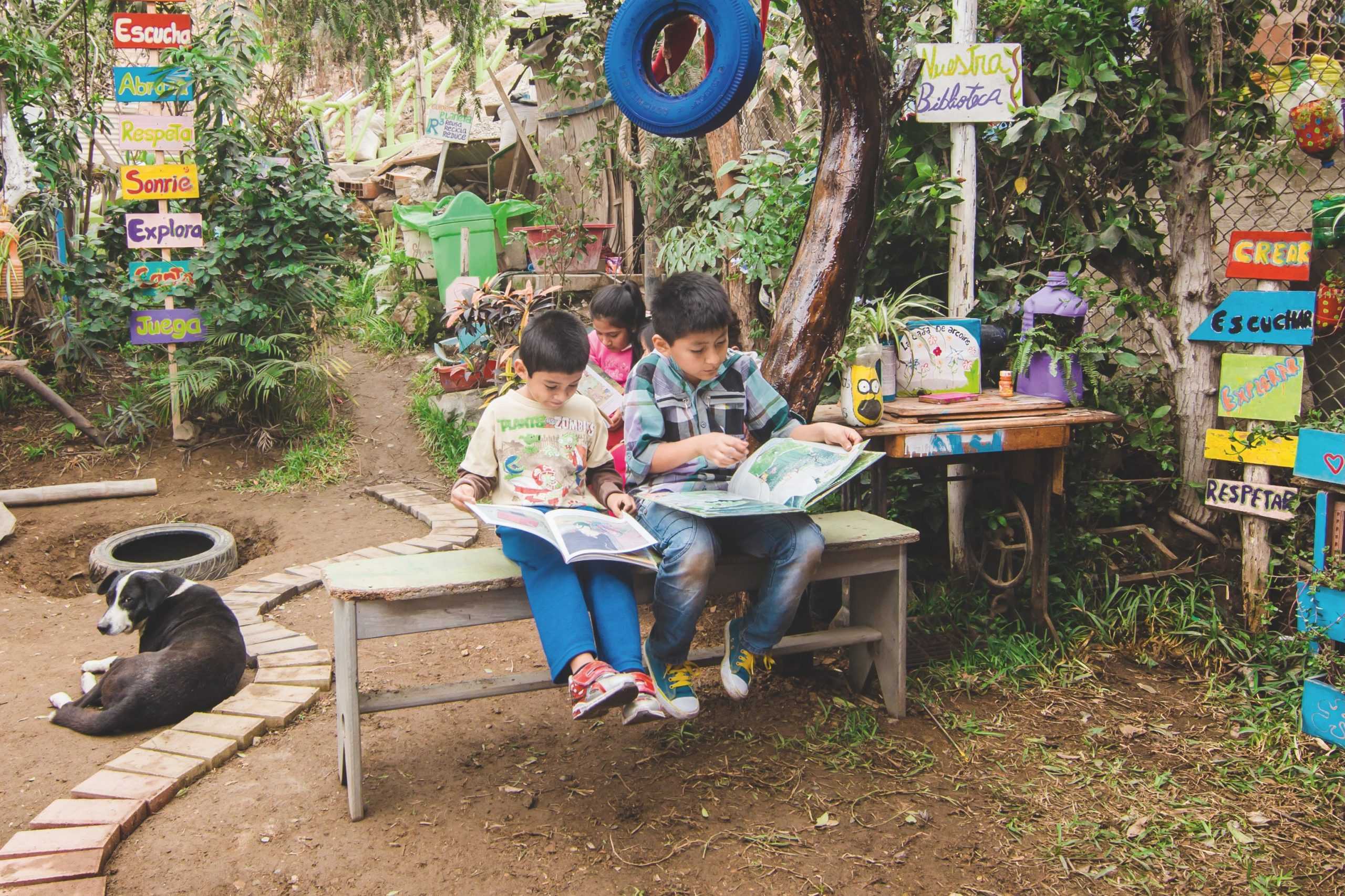 Två pojkar sitter och läser i vars en bilderbok.