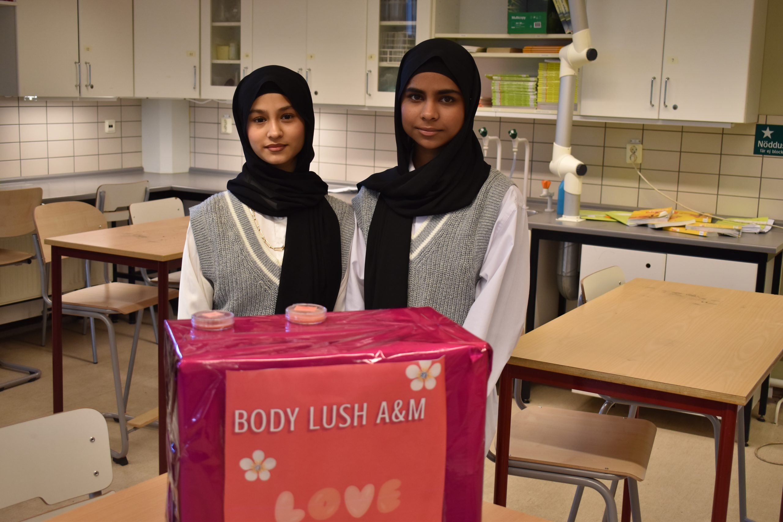 Två elever står framför låda med egentillverkade saker.
